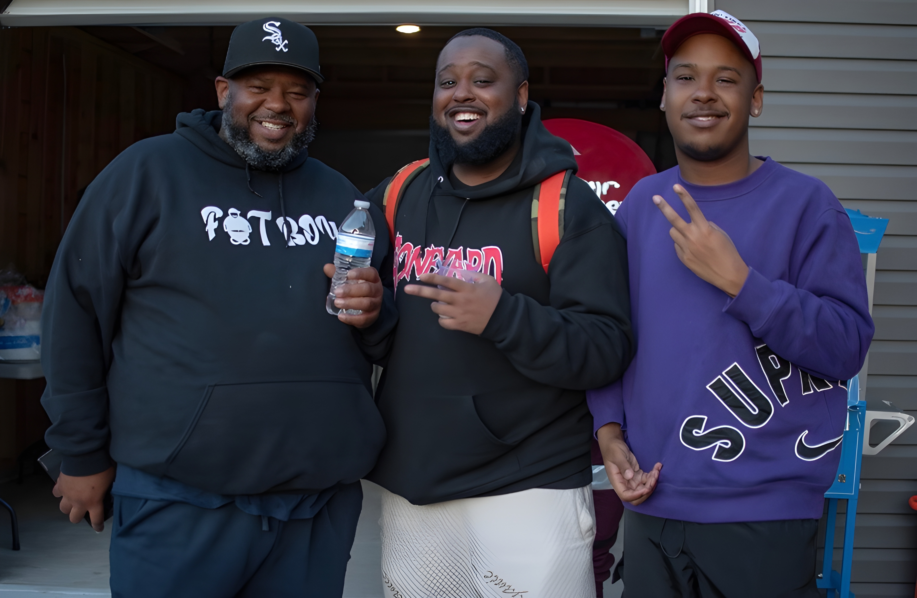 Ashton smiling with family and friends outside, wearing a Howard sweatshirt